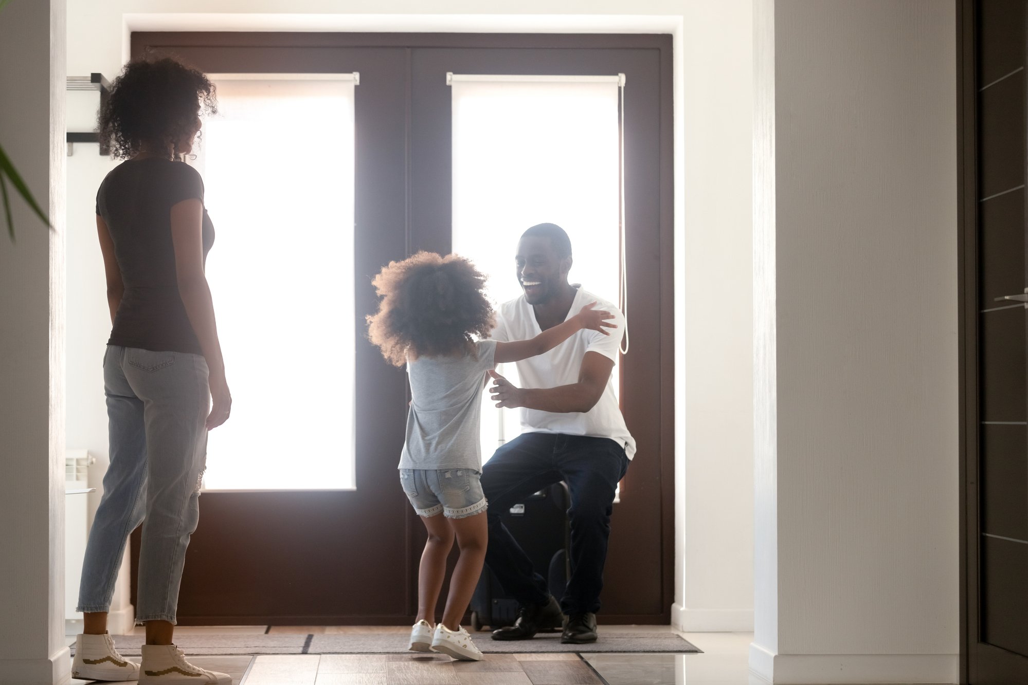 Happy kid daughter excited to meet african dad arriving home